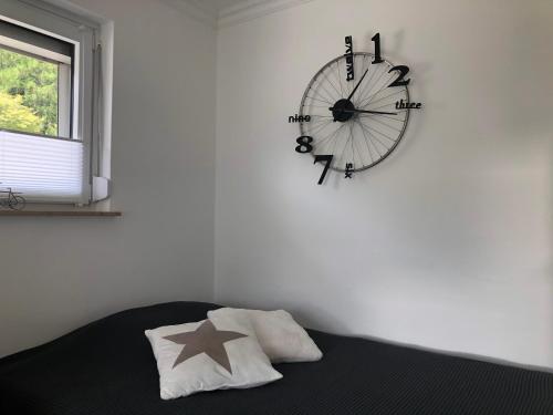 a clock hanging on a wall next to a bed at Traumwohnung 5 Min zum Bike Park in Willingen