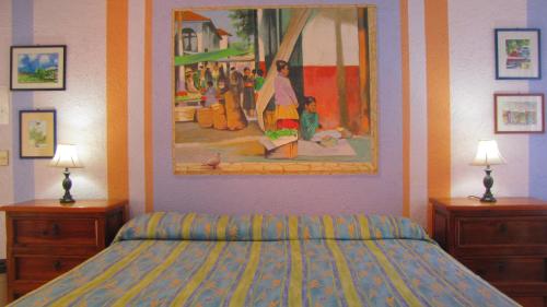 La Paloma Oceanfront Retreat في سان باتريسيو ميلاكي: غرفة نوم بسرير ودهان على الحائط