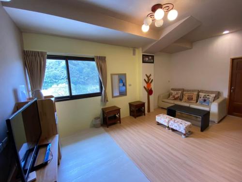 uma sala de estar com um sofá e uma televisão em Fu Chuan Garden em Nanzhuang