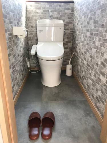 a bathroom with a toilet and a pair of shoes at 大型貸切別荘 HOUSE ASA 最大22名 サウナ BBQ ホームカラオケ 焚き火 from九十九里海岸歩7分 in Kujukuri