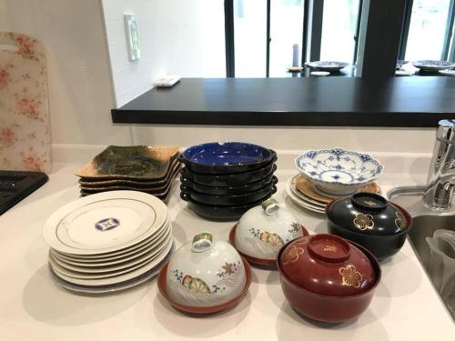 a group of plates and bowls and plates on a counter at 大型貸切別荘 HOUSE ASA 最大22名 サウナ BBQ ホームカラオケ 焚き火 from九十九里海岸歩7分 in Kujukuri