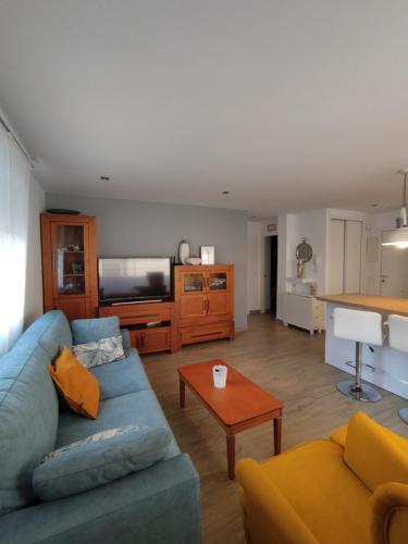 ein Wohnzimmer mit einem blauen Sofa und einem TV in der Unterkunft Alojamiento La Unión in Fuengirola