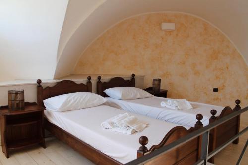 2 Betten mit weißer Bettwäsche und Kissen in einem Zimmer in der Unterkunft Buen Retiro - Casa Vacanze in Depressa