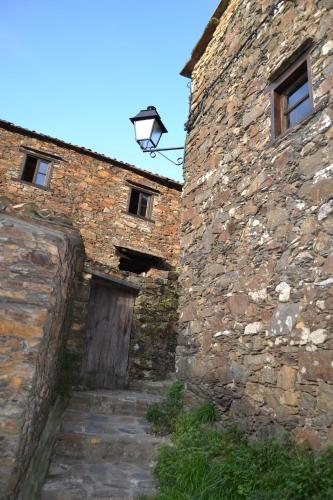 an old brick building with a door and a street light at Talasnal Montanhas de Amor in Lousã