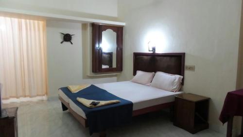 a bedroom with a large bed and a mirror at Marina guest house in Kovalam