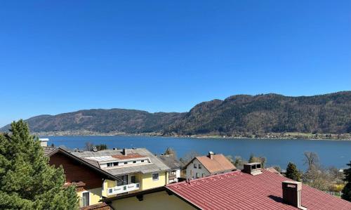 a view of a town with a lake and mountains at Gemütliche Seeblickwohnung Lara in Sattendorf