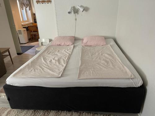 2 łóżka w pokoju z różowymi poduszkami w obiekcie Little house with sauna w mieście Lahti