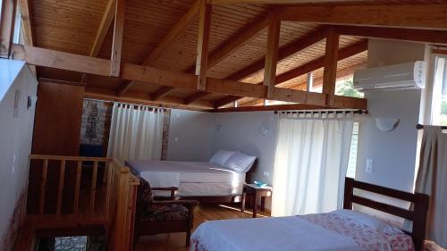 a bedroom with two beds and a wooden ceiling at Kassi's House in Marantochori