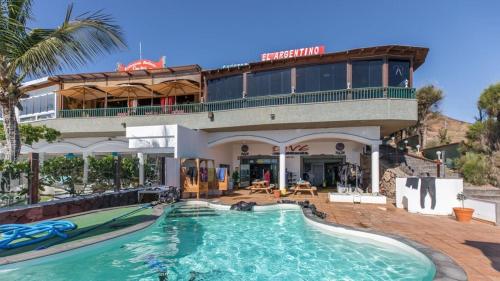 una casa con piscina delante de un edificio en Las Brisas 71, en Playa Blanca