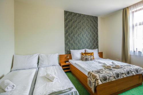 a bedroom with two beds and a window at Hotel Anna Villa in Balatonföldvár