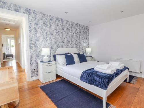um quarto com uma cama e uma parede azul e branca em Lily Pad em Rhyl