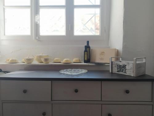 a counter top with bowls and a bottle of wine at Gelhaus 1935 in Hydra