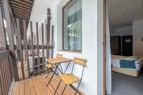 a balcony with two chairs and a table and a bed at Park Hotel Asenevtsi in Veliko Tŭrnovo