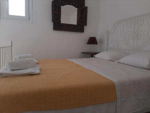 a bedroom with a large bed and a mirror at Vourkari BayHouse in Vourkarion
