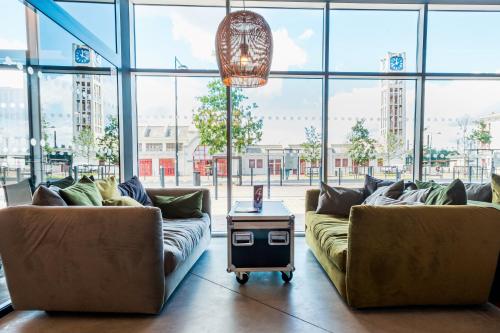 a living room with two couches and a table at ibis Styles Lens Centre Gare in Lens