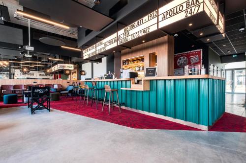 a bar in a restaurant with a red rug at ibis Styles Lens Centre Gare in Lens