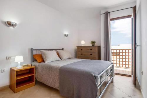 een slaapkamer met een bed en een groot raam bij Modern Duplex in Puerto del Carmen in Tías