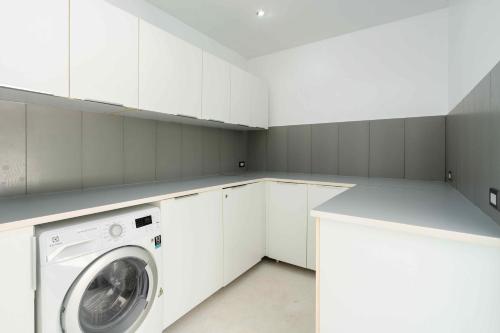 a white laundry room with a washing machine in it at Villa Best View Samui managed by Villa For You in Koh Samui 