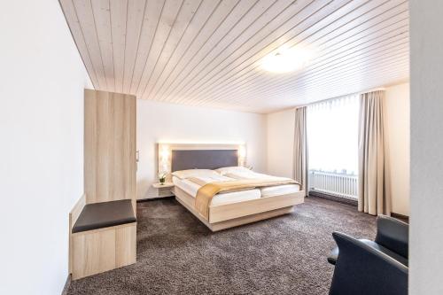 een slaapkamer met een bed en een groot raam bij Hotel zum goldenen Kreuz in Frauenfeld