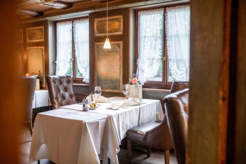 a dining room with a table and chairs and windows at Hotel zum goldenen Kreuz in Frauenfeld