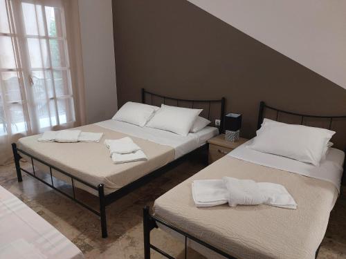 two beds in a room with white towels on them at AK VILLAGE ROOMS in Drepana