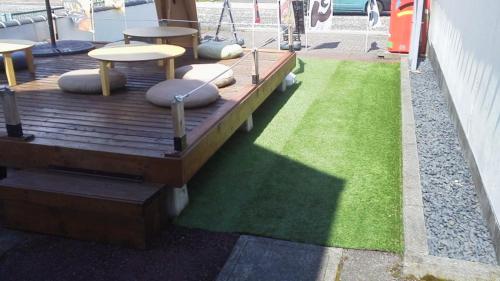 a wooden deck with benches and a green lawn at Jemsty Inn Hakone Ashinoko in Hakone