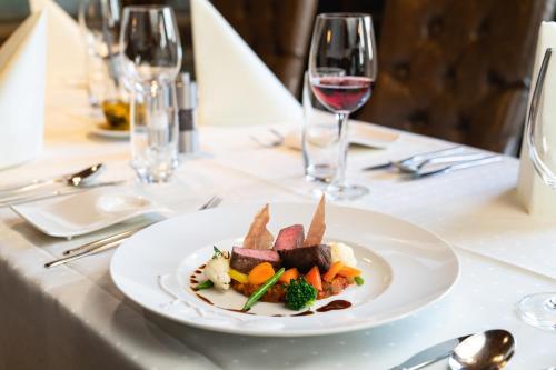 a plate of food on a table with wine glasses at Hotel zum goldenen Kreuz in Frauenfeld