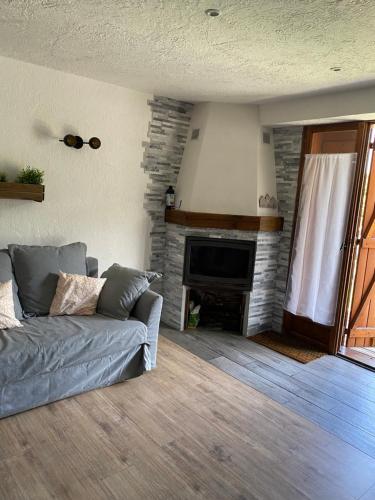 ein Wohnzimmer mit einem Sofa und einem Kamin in der Unterkunft Bas de chalet au pied des pistes Cambre d'aze in Saint-Pierre-dels-Forcats