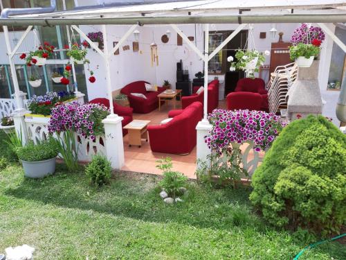 a patio with red chairs and purple flowers and plants at Villa Vraji in Hrabušice