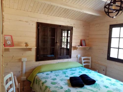 una camera con un letto in una baita di tronchi di Agriturismo Rosso Lampone a Cerreto Laziale