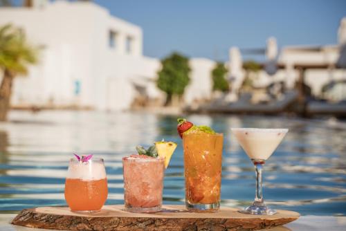 four drinks on a tray next to a pool at Meltemi Blu - Adults Only in Perissa