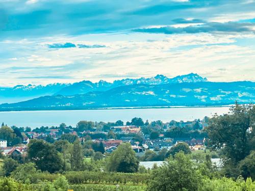 une ville avec un lac et des montagnes en arrière-plan dans l'établissement Hotel Montfort-Schlössle, à Lindau