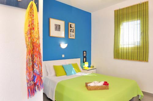 1 dormitorio con cama y pared azul en Aiolis Studios, en Porto Koufo