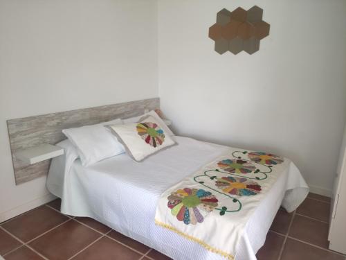 ein Schlafzimmer mit einem weißen Bett mit Blumen darauf in der Unterkunft apartamento genil in Granada