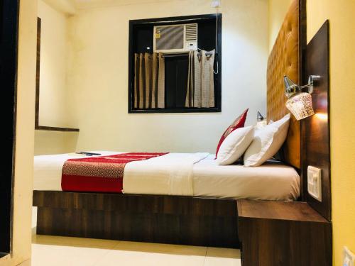 una camera d'albergo con letto e specchio di Hotel New Silver Elite a Mumbai