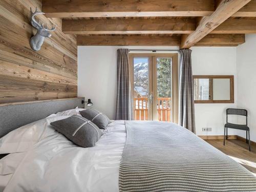 a bedroom with a large bed with a wooden ceiling at Chalet Méribel, 7 pièces, 12 personnes - FR-1-566-30 in Les Allues