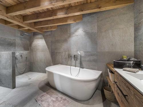ein Badezimmer mit einer weißen Badewanne und einem Waschbecken in der Unterkunft Chalet Méribel, 7 pièces, 12 personnes - FR-1-566-30 in Les Allues