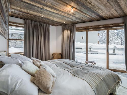 ein Schlafzimmer mit einem großen Bett und weißen Kissen in der Unterkunft Duplex spacieux pour 14 pers. avec sauna, terrasse et parking, au pied des pistes - Méribel Village - FR-1-566-11 in Les Allues