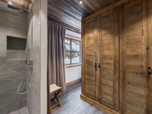 ein Badezimmer mit Dusche und Holztür in der Unterkunft Duplex spacieux pour 14 pers. avec sauna, terrasse et parking, au pied des pistes - Méribel Village - FR-1-566-11 in Les Allues