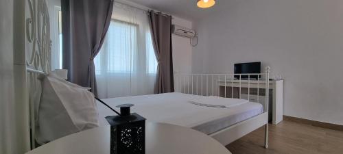 コスティネシュティにあるVila DVG Costinestiの白い小さな部屋(ベッド1台、テーブル付)