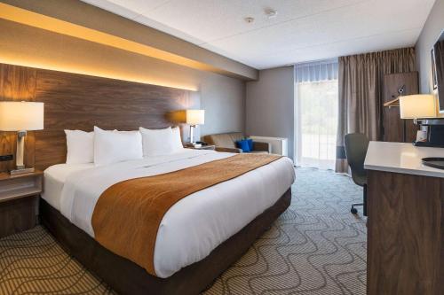 um quarto de hotel com uma cama grande e uma secretária em Comfort Inn Lakeshore em North Bay