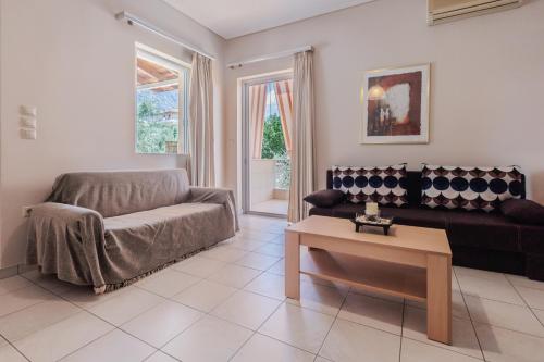 een woonkamer met een bank en een tafel bij Paralia Vergas Apartments in Verga Kalamata
