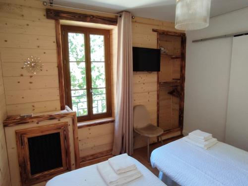 a bedroom with two beds and a window at BO LODGE in Le Bourg-dʼOisans