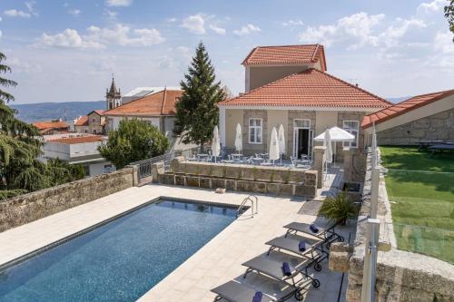 a villa with a swimming pool and a house at Casa das Muralhas in Covilhã