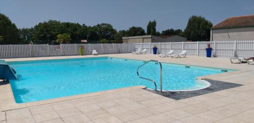 a large swimming pool with a water hose in it at Le Vert Océan in Talmont