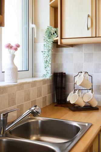 a kitchen counter with a sink and a window at Paralia Vergas Apartments in Verga Kalamata