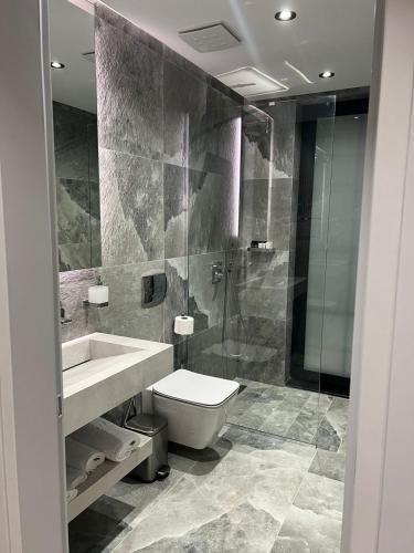 a bathroom with a toilet and a sink and a shower at Rozafa Palace Hotel in Sarandë