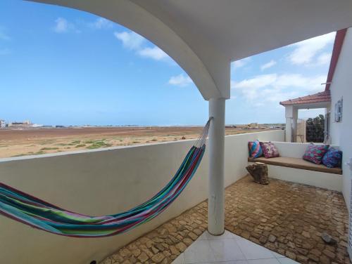 a hammock on a balcony with a view of the desert at Casa Djarmai Boutique Apartments in Vila do Maio
