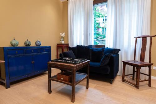 a living room with a blue couch and a table at Villa Gallo 1915, luxurious villa with garden and SPA in Venice-Lido
