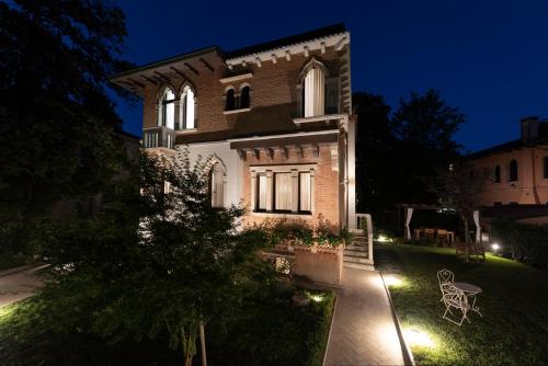 a house with lights on the yard at night at Villa Gallo 1915, luxurious villa with garden and SPA in Venice-Lido